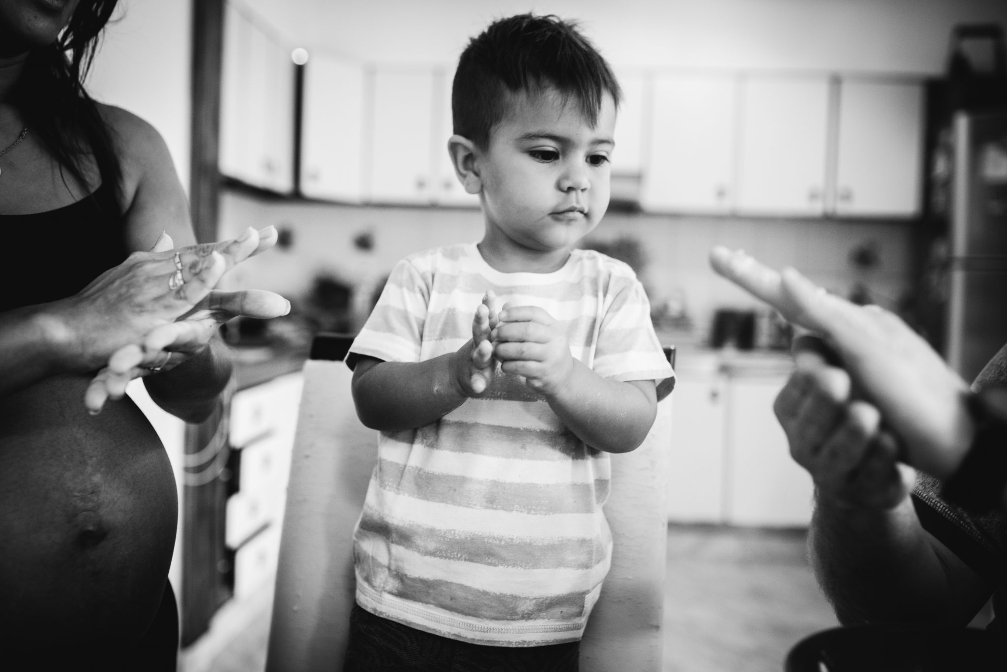 Toddler cooking with his parents. They're making chipá during a pregnancy (maternity) photo shoot.