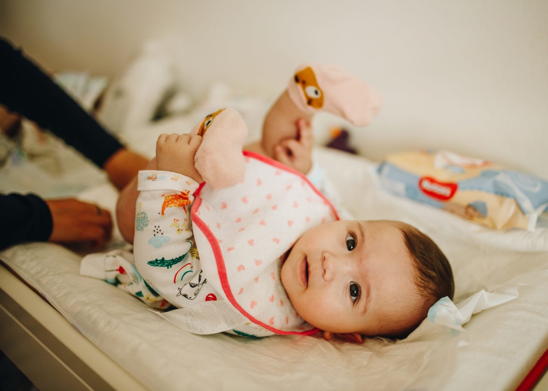 baby being cleaned by her mom, looking at the camera, documentary photo shoot