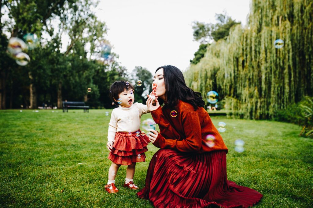 Mom and her daugther playing with bubbles in Vondelpark, Amsterdam, during their vacation.