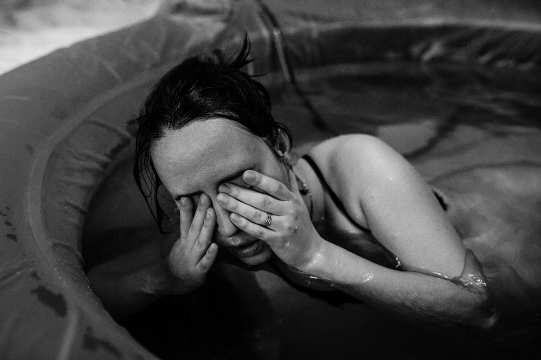 woman rubing her face between contractions.