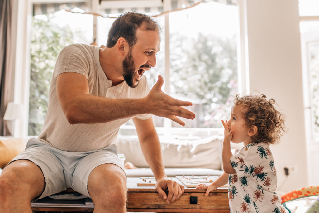 Dad playing with his little daughter, sending kisses to the air