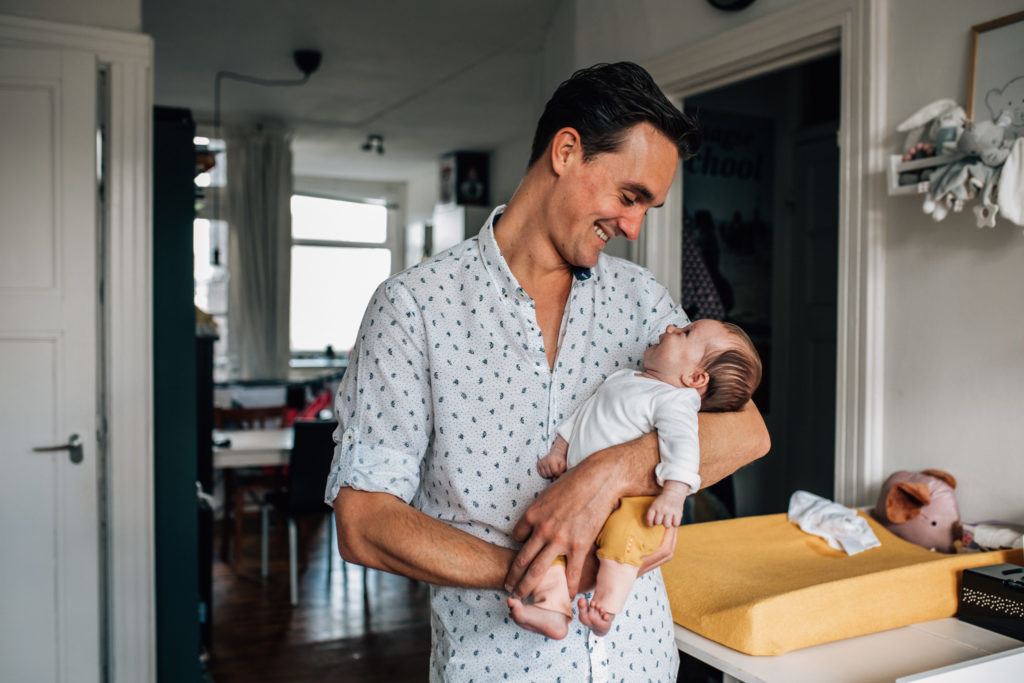 dad holding his baby, they're both smiling