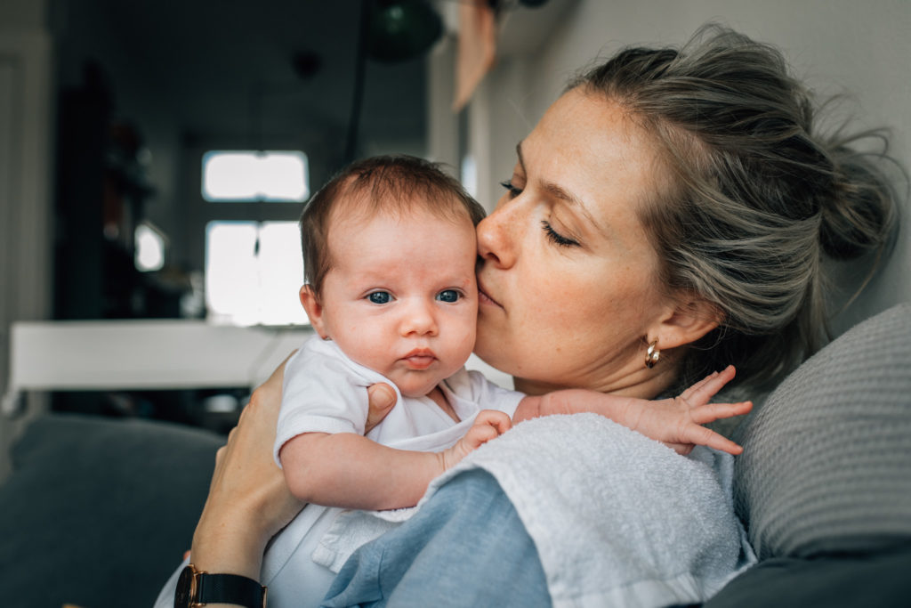 Mom smelling her newborn baby's head.