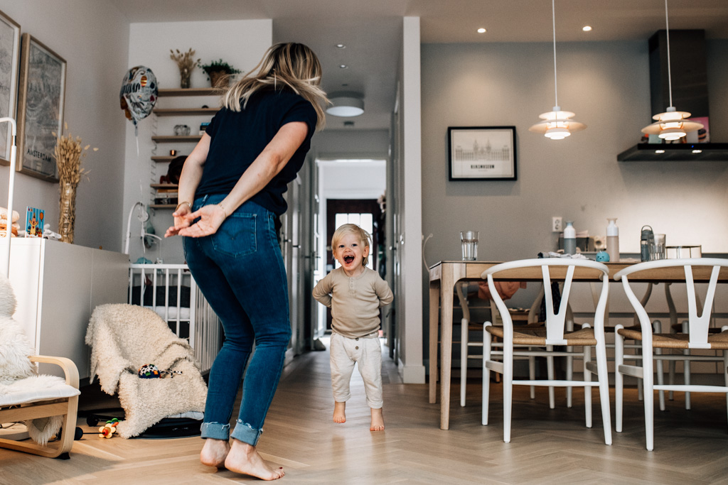 Mom and toddler jumping together in the kitchen