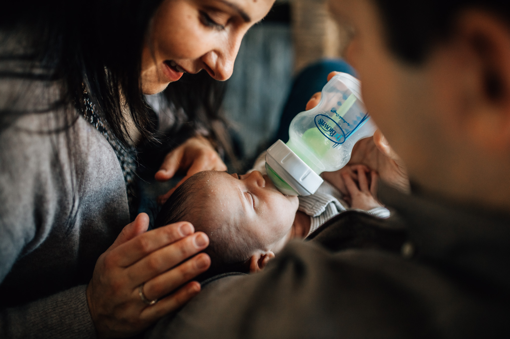 Mom caressing her newborn baby while being fed