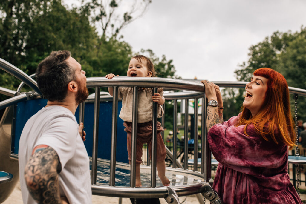 For this amazing family photoshoot after the little one had breakfast at home, we took a walk to the park. In this image you can see her smiling towards her dad, playing on the slide in Amsterdam.