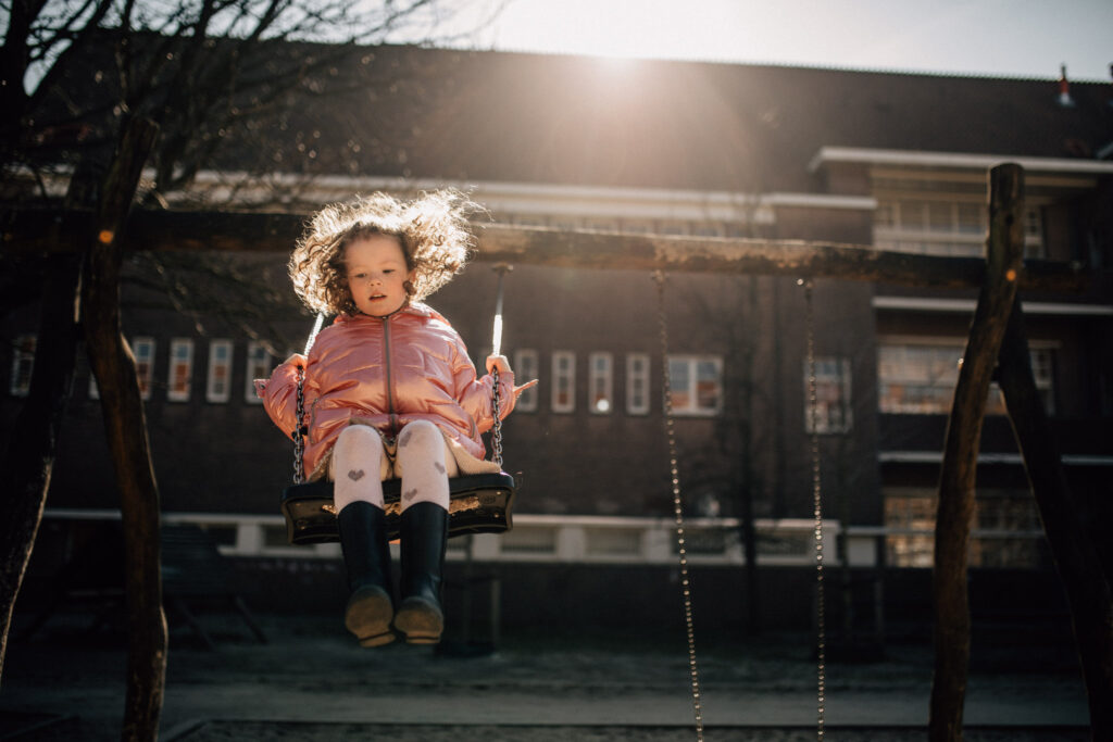 Girl playing on the hammocks in a playground in Amsterdam zuid. 